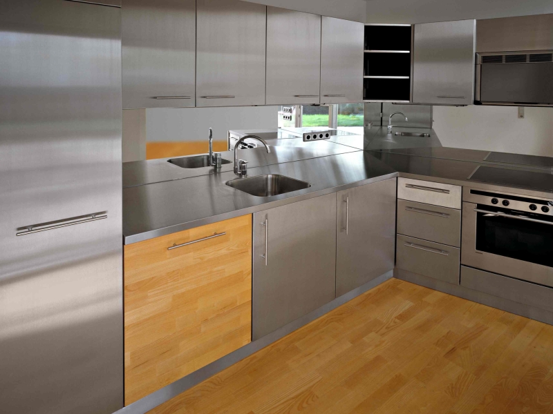 Haushaltsküche in Edelstahl mit integrierten Geräten und Holzakzenten