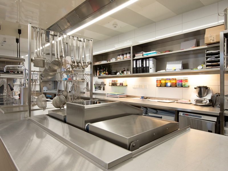 Großküche mit Sonder-Formrohrgestell als Kellengehänge am Herd