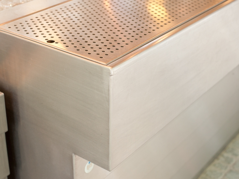 Tropftasseneinsatz mit Perforierung + Detail-Sicht auf die allseitig fugenlose Ausführung der gesamten Schankanlage