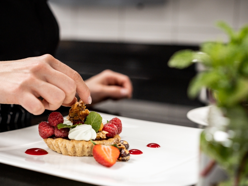 Anrichten einer Süßspeise in der Patisserie (in der Großküche)