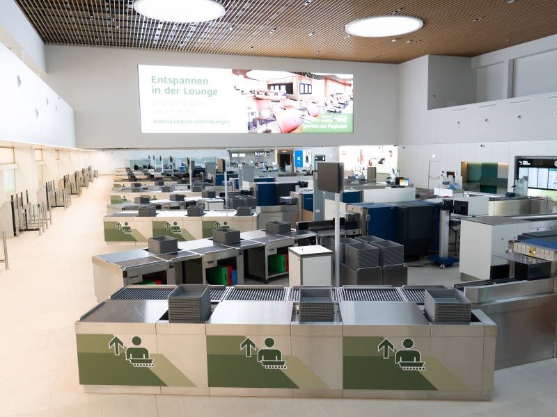 Übersichtsfoto der Flughafen/Sicherheitskontrolle (Fokus auf Anfang wo sich Passagiere entkleiden bzw. die persönlichen Gegenstände abgeben) inklusive Kistenspender
