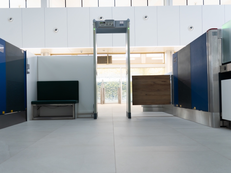 Personenkontrolle in der zentralen SIKO am Flughafen Wien: Durchgangsschleuse inklusive seitlicher Schwenktür und Sitzbank im Visitierbereich